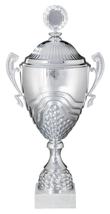 Der Wanderpokal Wiesbaden 412 mm - 680 mm PK758710-W-E50 mit silberner Oberfläche, verzierten Griffen und einem dekorativen Sockel weist ein strukturiertes Design auf seinem Korpus auf und ist oben mit einem kleinen runden Ornament verziert. Das Ganze steht elegant auf einem weißen quadratischen Sockel. Dieses Stück dient als exklusives Design- und Erinnerungsstück.